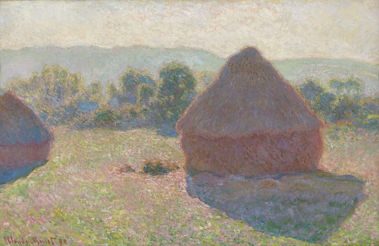 A sunlit haystack dominates the foreground, its rounded form set against a hazy rural landscape.
